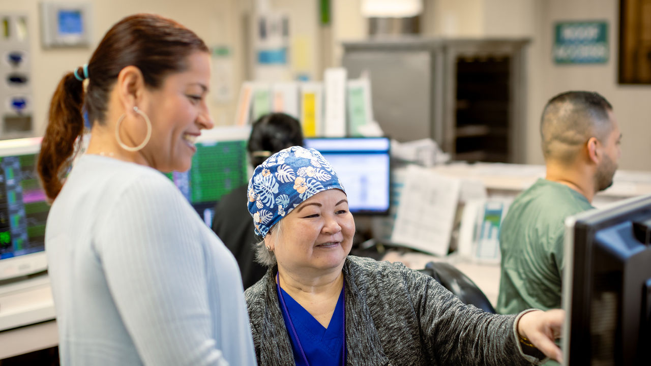 Healthcare professionals smiling looking at computer screen
